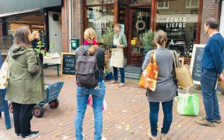 mensen krijgen uitleg bij winkel bij zero waste wandeltours