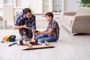 vader repareert skateboard met zoon