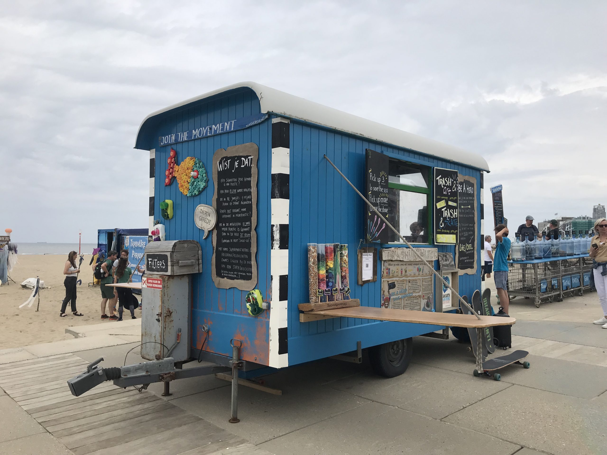 blauwe pipo-wagen op het strand van TrashUre Hunt