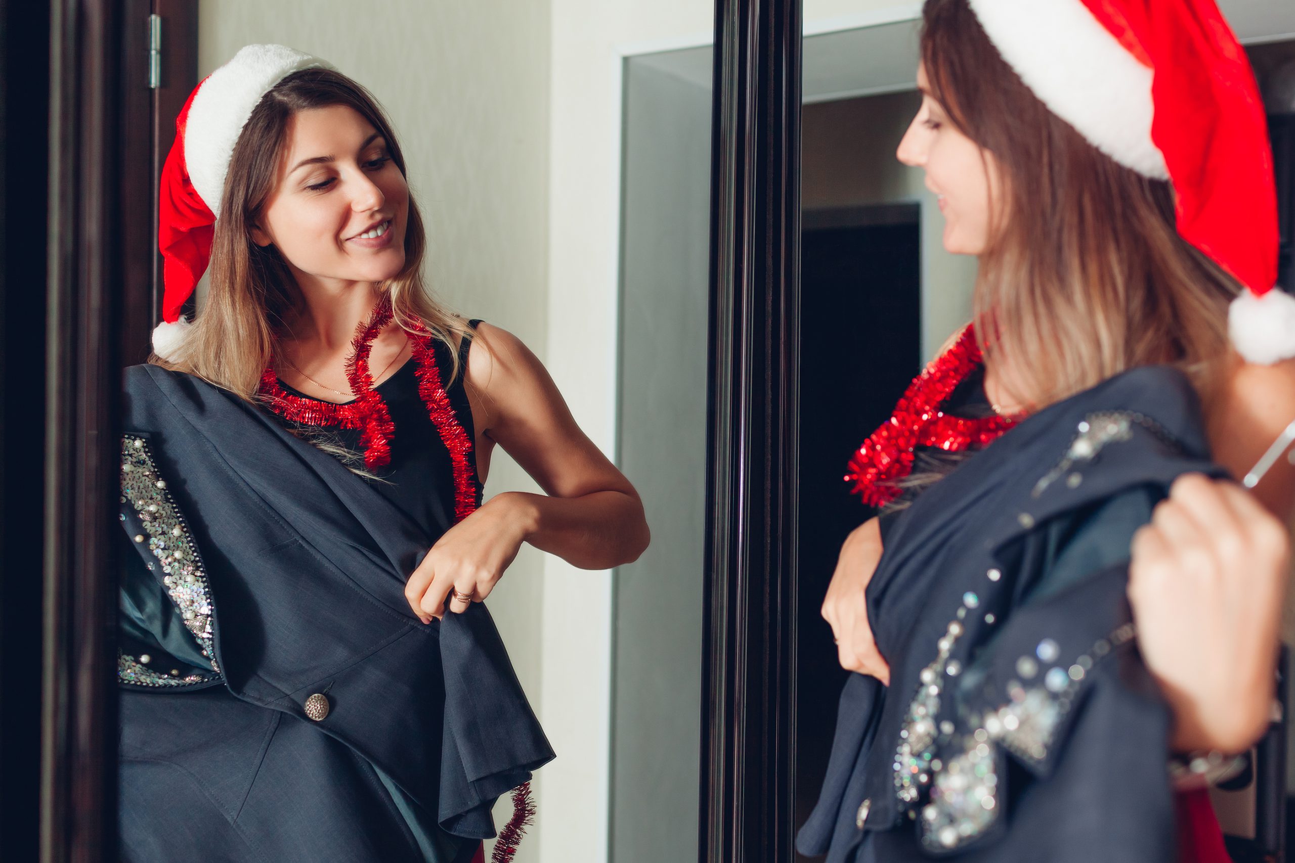 vrouw past feestoutfit voor spiegel