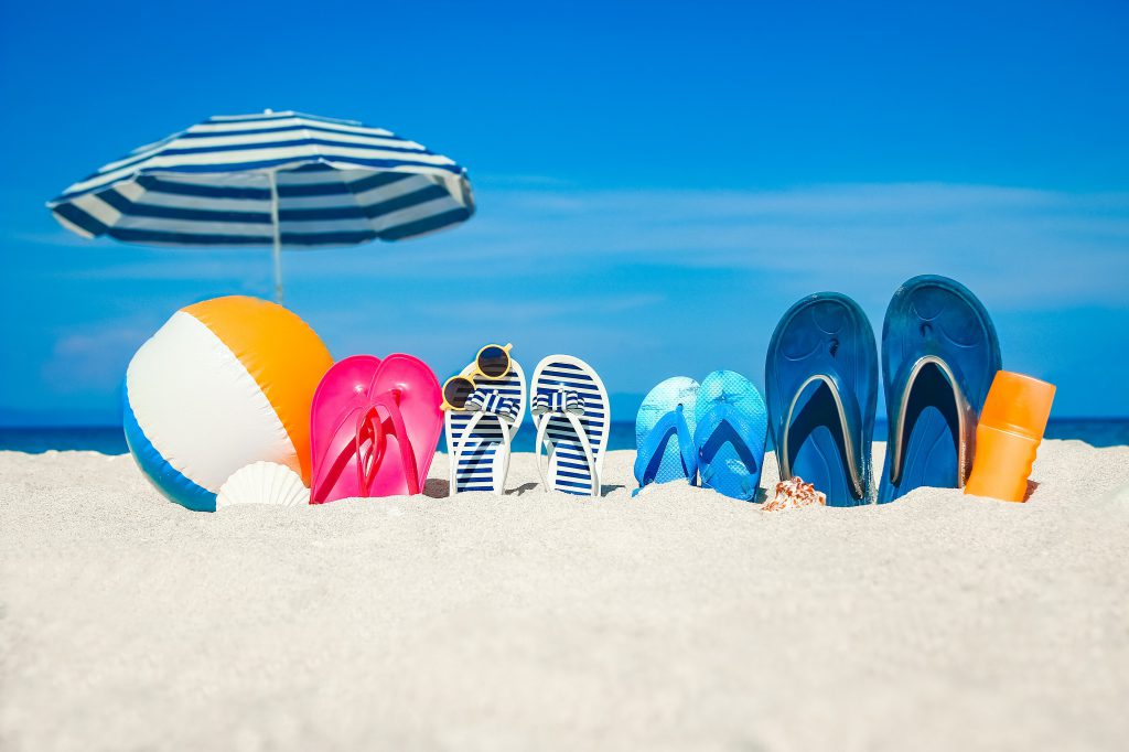 slippers, strandbal en parasol op het strand